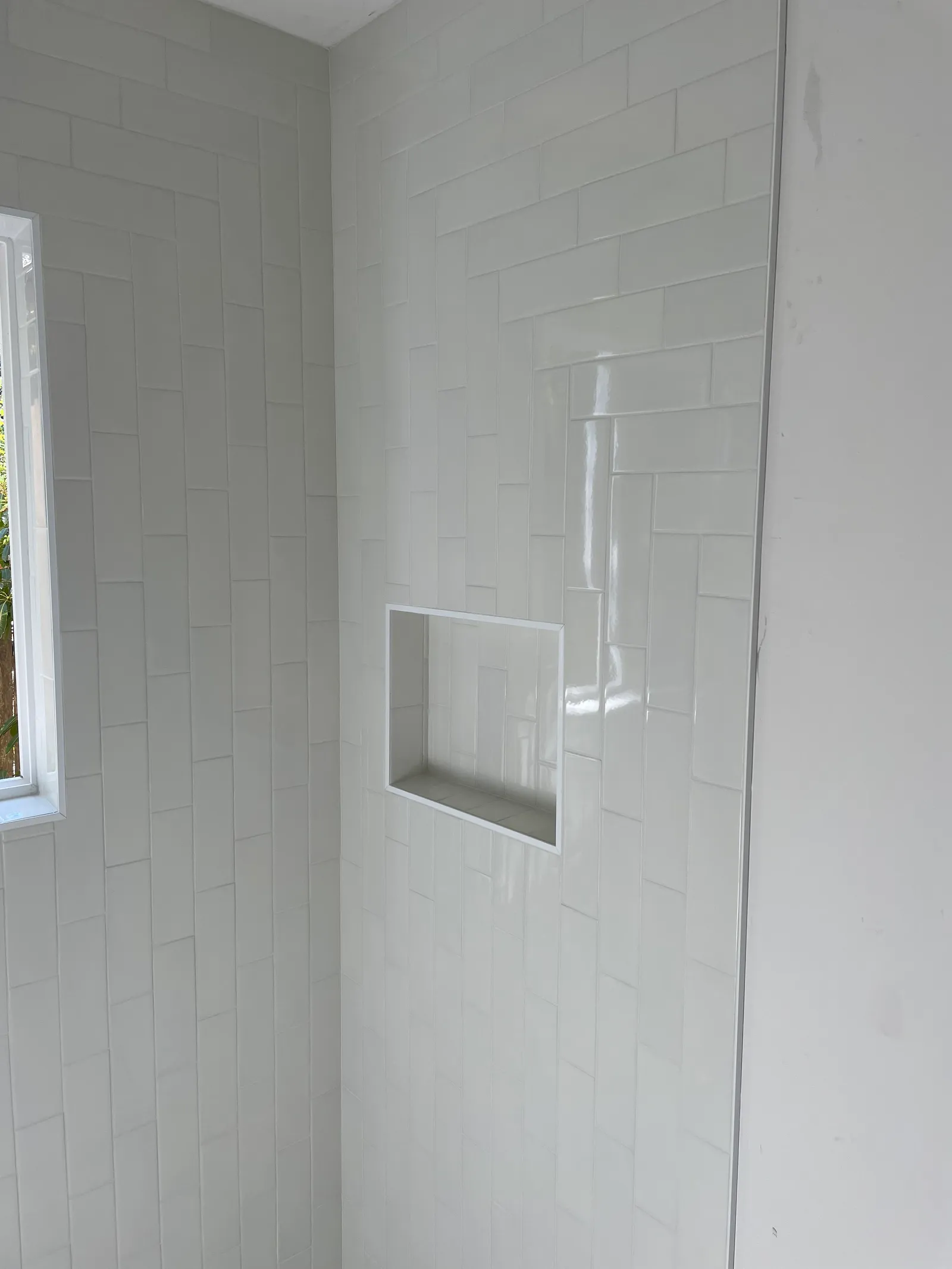 White subway tile shower with built-in niche